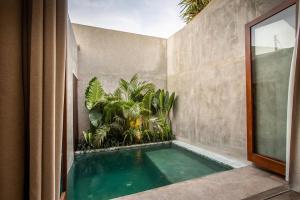 a swimming pool in the corner of a house at The Echo Studios HUGE 100m to beach 1 in Badung