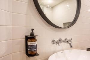 a bathroom with a bottle of soap on a sink at The Echo Studios HUGE 100m to beach 1 in Badung +3 photos