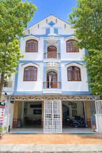 a blue and white building with windows and trees at Thanh Tâm Hotel in Can Tho
