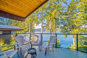 a porch with chairs and a view of the water at Seaside Haven -Hot Tub with Oceanfront View in Port Renfrew