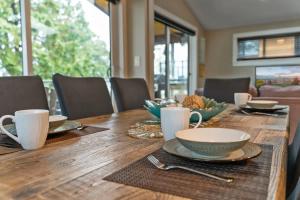 a wooden table with plates and cups on it at Seaside Haven -Hot Tub with Oceanfront View in Port Renfrew