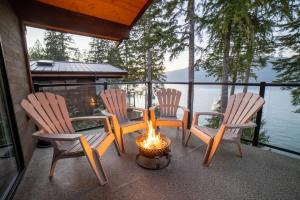 four chairs and a fire pit on a porch with a view of the water at Seaside Haven -Hot Tub with Oceanfront View in Port Renfrew