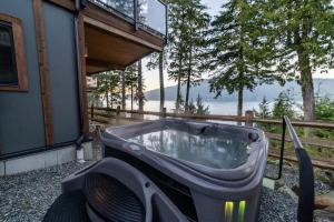 a bath tub sitting outside of a house at Seaside Haven -Hot Tub with Oceanfront View in Port Renfrew