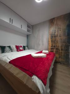 a bedroom with a red blanket on a bed at Badash Tiny Village - Tiny Houses with Heated Pool & BBQ in Polovragi +61 photos
