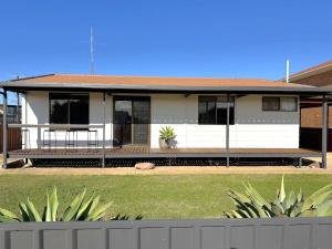 a white house with a fence in front of it at Wilgra By The Beach in Wauraltee