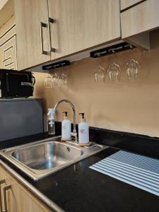 a kitchen sink with two soap dispensers on it at 963 D shore 1 in Manila +45 photos