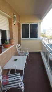 balkon z białym stołem i krzesłami w obiekcie Apartamento Eduardo Dato w Sewilli