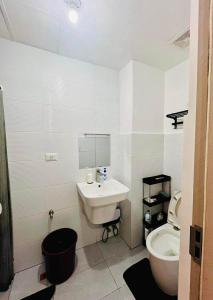 a white bathroom with a sink and a toilet at Bernwood Tower IloIlo - Heavens Crib in Iloilo City