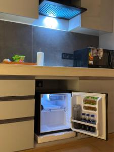a small refrigerator with its door open in a kitchen at Galaxy Blue sapphire Plaza Square Residency in Ghaziabad