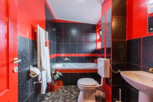 a red bathroom with a toilet and a sink at Pensiunea ANA Vistisoara in Vistisoara +61 photos