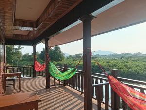 two hammocks on a porch with a view of the forest at Thiptavanh guesthouse in Don Det