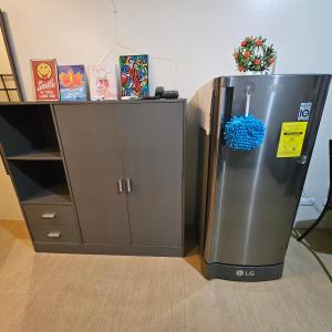 a stainless steel refrigerator next to a cabinet at Avida Davao condo Studio type in Davao City