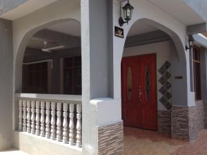 a front door of a house with a red door at Nur Muslim 2 Homestay At Kota Bharu in Kota Bharu
