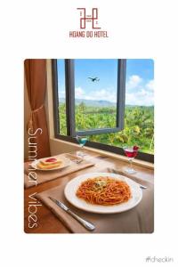 a plate of pasta on a table with a window at Hoàng Đô Hotel in Phú Quốc