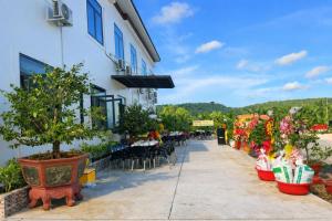 a building with potted plants and tables and chairs at Hoàng Đô Hotel in Phú Quốc