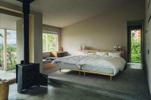 a bedroom with a large bed and a fireplace at SANU 2nd Home CURRENT Awajishima in Awaji