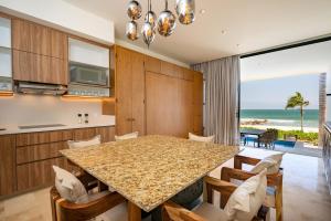 a kitchen and dining room with a table and a view of the ocean at Beachfront townhouse TH03A in Cruz de Huanacaxtle