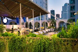 a restaurant with tables and chairs in a city at Baitong Hotel & Resort Phnom Penh in Phnom Penh