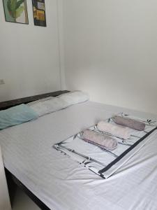a white bed with two pink towels on it at Chelle's apartelle-inn in El Nido +19 photos