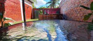 a pool of water in front of a brick building at Mítica, Casa Hospedaje in Sauce