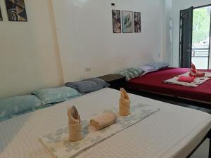 a room with two beds with towels on a table at Chelle's apartelle-inn in El Nido