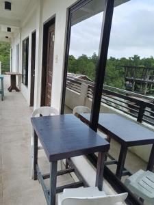 a table and chairs on the balcony of a house at Chelle's apartelle-inn in El Nido