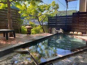 a pool of water in a yard with a wooden deck at 旬樹庵　菊水 in Chikuma