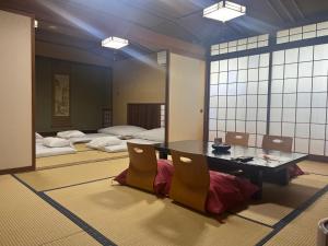 a room with a table and two beds at 旬樹庵　菊水 in Chikuma