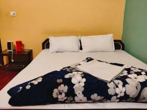 a bed with a black and white blanket on it at Corbett Bungalow Stay- Private Garden Stay Near Jim Corbett in Rāmnagar