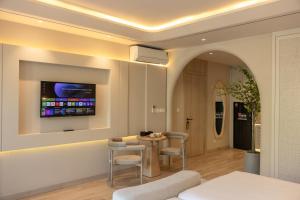 a living room with a tv on a wall at Emerald Boutique Hotel Phú Quốc in Phú Quốc