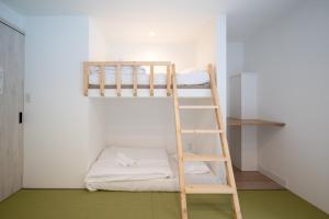 a bunk bed in a room with a ladder at Grouse Lodge -5 mins to ski field by walk- in Furano +36 photos