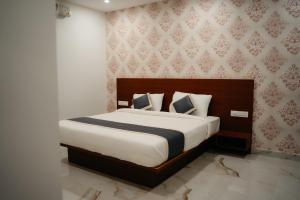 a bedroom with a large bed with a wooden headboard at Fenna Resort And Spa, coorg in Kushālnagar +21 photos