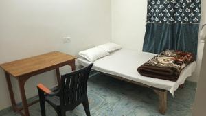 a small bedroom with a small table and a bed at Sujata Buddha Homestay in Bodh Gaya