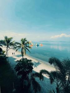 an airplane is flying over a beach with palm trees at Club Balai Isabel Front Taal Lake & Volcano View in Talisay