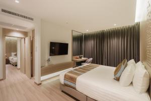 a hotel room with a large bed and a television at Fifth Pattaya Jomtien By Shiwalai Int in Jomtien Beach +147 photos