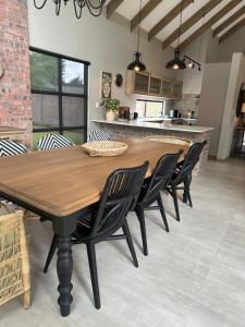 a dining room with a wooden table and chairs at Fallen Oak Villa 2 in George