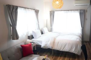ein Schlafzimmer mit einem weißen Bett und einem Fenster in der Unterkunft 宿Luce in Okayama