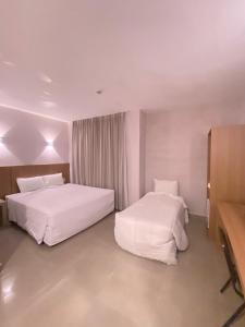 a hotel room with two beds and a television at Hotel Abba Goiana PE in Goiana +35 photos