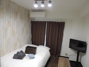 a bedroom with a bed with a box on it at フレクション大工町 in Miyazaki