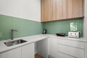 a kitchen with white cabinets and a sink at Harborview Modern Studio 11F in Victor Harbor