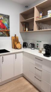 eine Küche mit weißen Schränken und weißen Arbeitsplatten in der Unterkunft Azure Abode in Broulee