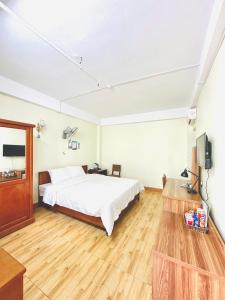 a bedroom with a bed and a television in it at Oriio Hotel Cát Bà in Cat Ba