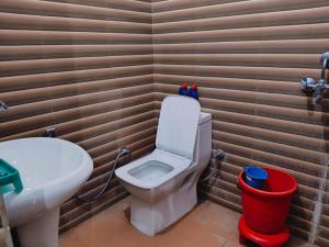 a bathroom with a toilet and a sink at Corbett Bungalow Stay- Private Garden Stay Near Jim Corbett in Rāmnagar