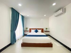 a bedroom with a large bed with blue curtains at HomeStore Apartment in Siem Reap