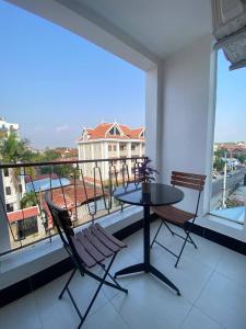 a balcony with a table and two chairs and a view at HomeStore Apartment in Siem Reap