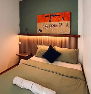 a bedroom with a bed with a painting on the wall at Happiness Hostel Private room in Phra Ae beach