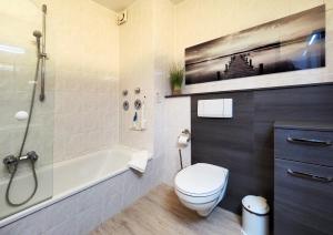 ein Bad mit einer Badewanne, einem WC und einer Dusche in der Unterkunft Fietje 206 - Hohen Wieschendorf in Hohen Wieschendorf