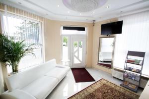 a living room with a white couch and a large window at C&S Hotel in Pinneberg