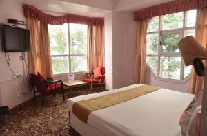 a hotel room with a bed and two windows at The Boho BNB in Shimla