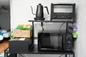 a microwave and a toaster oven on a black shelf at Retreat Ginoza in Ginoza
